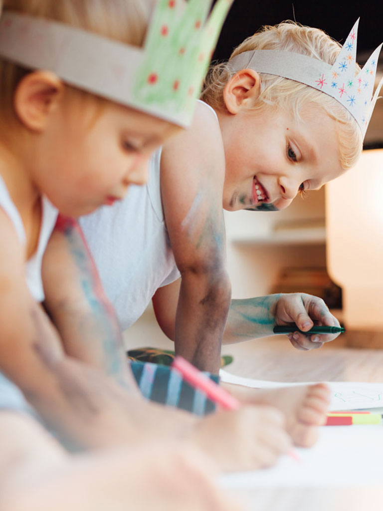 Zwei Kinder sitzen am Boden und malen mit Buntstiften während des Babysitter Kurses in Frankfurt